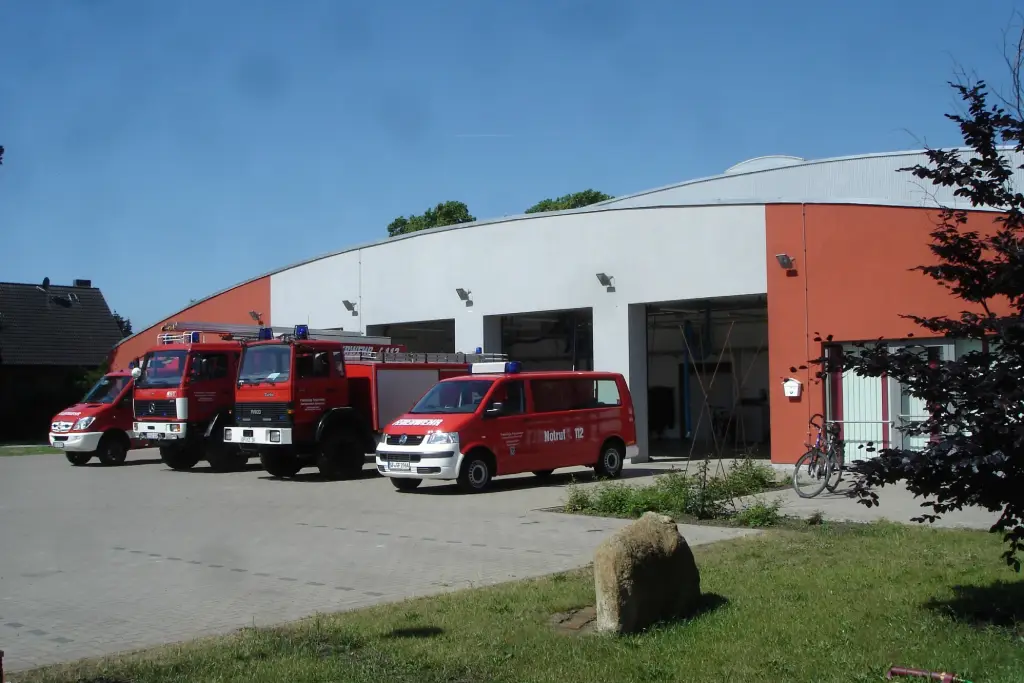 Feuerwehrhaus Müden-Dieckhorst mit Vorplatz, Einsatzfahrzeugen und Findling